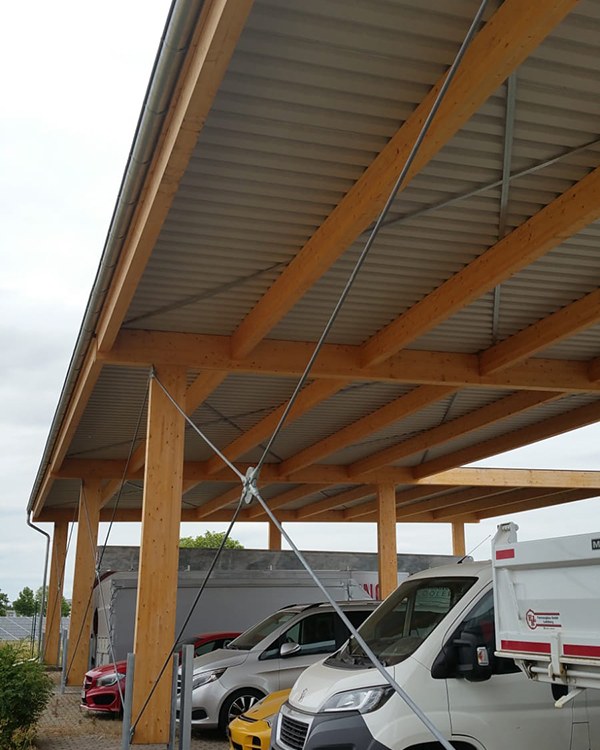 Foto des Ingenieurbüros: Untersicht des Holztragwerks eines fertig gebauten LKW-Carports